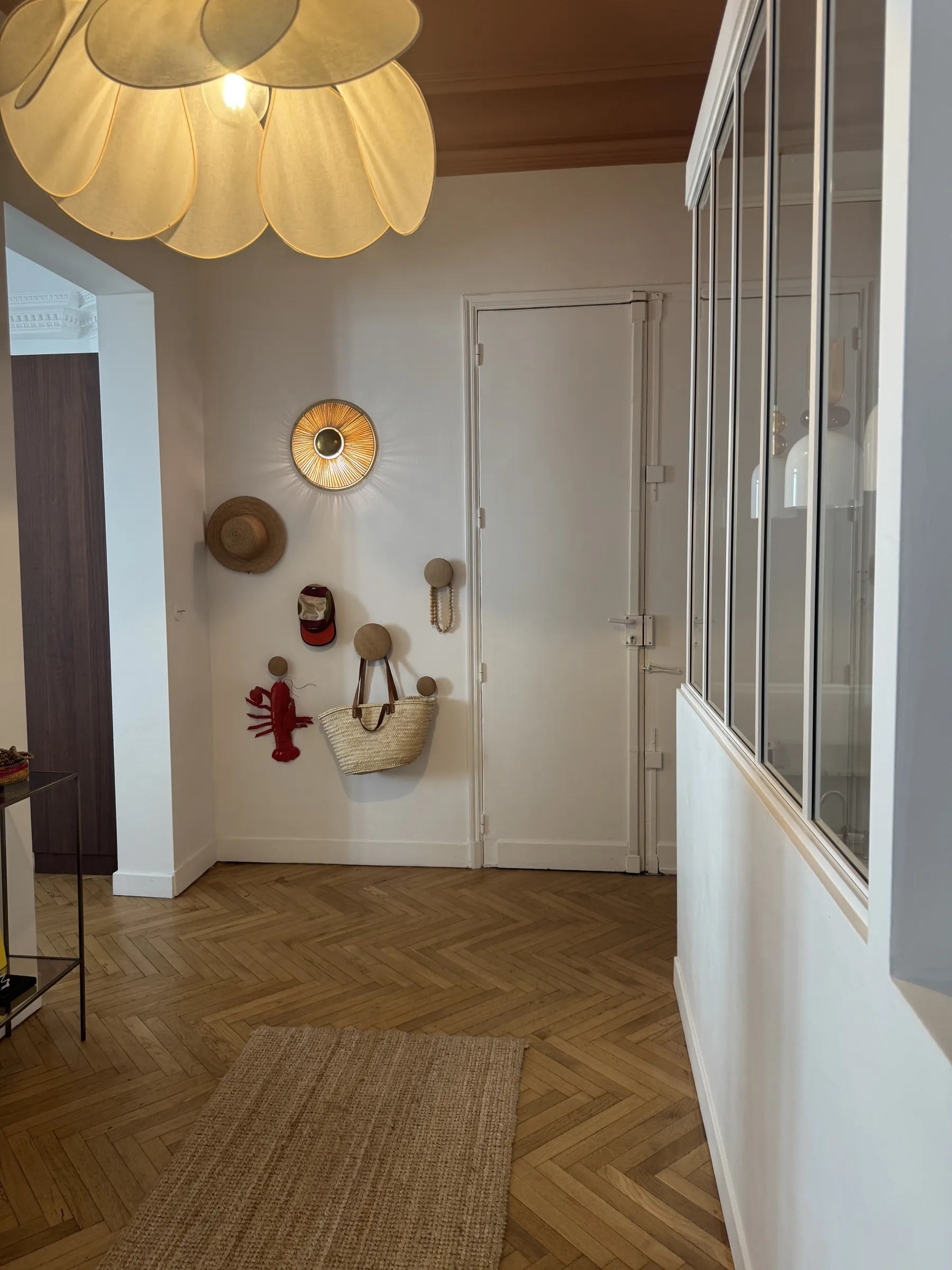 L'entrée — vestiaire, applique fleur, porte vitrée