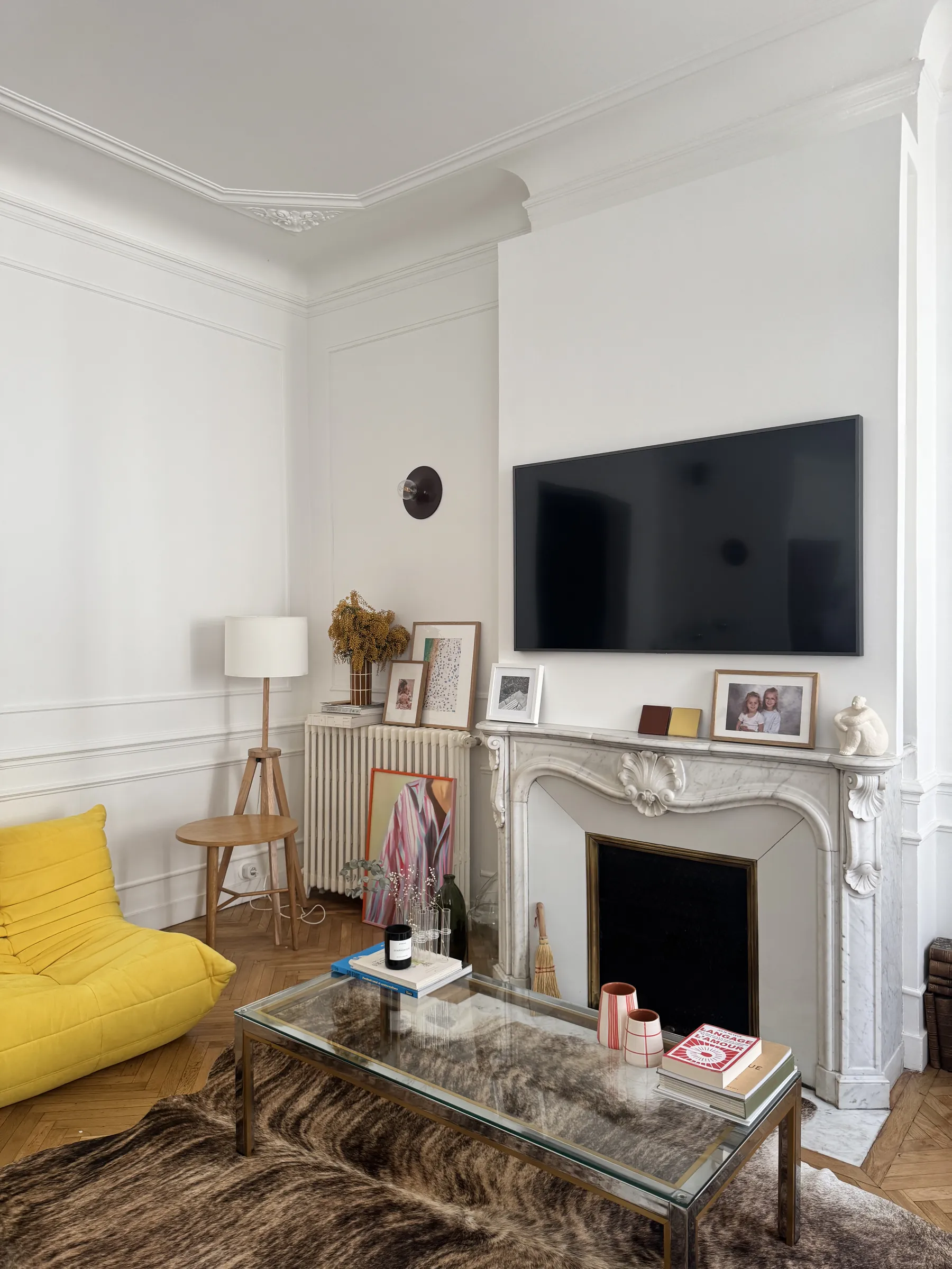 Coin télé — cheminée, miroir doré, parquet point de Hongrie